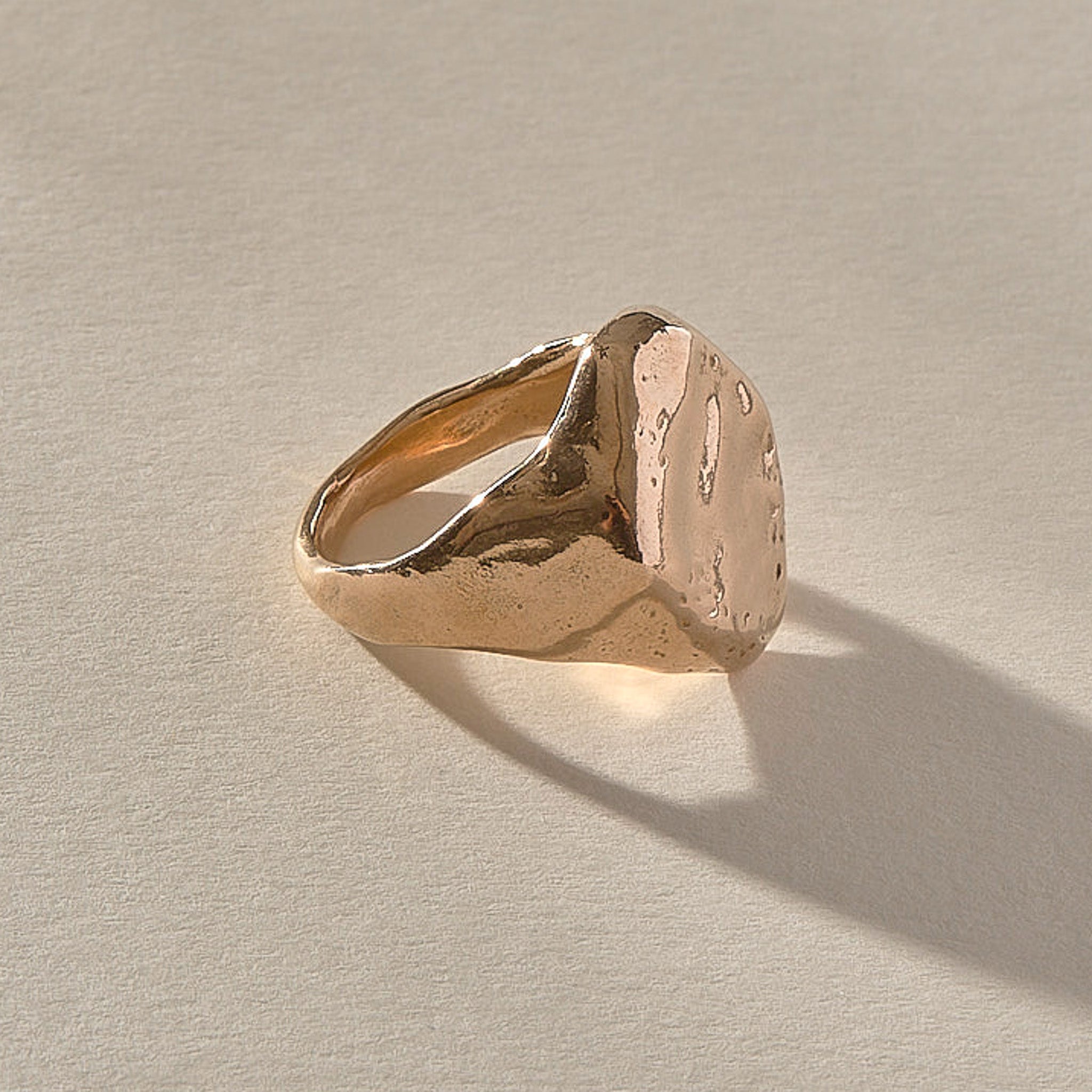 Heritage Textured Signet Ring in recycled bronze at an angle, showing the dappled signet face.