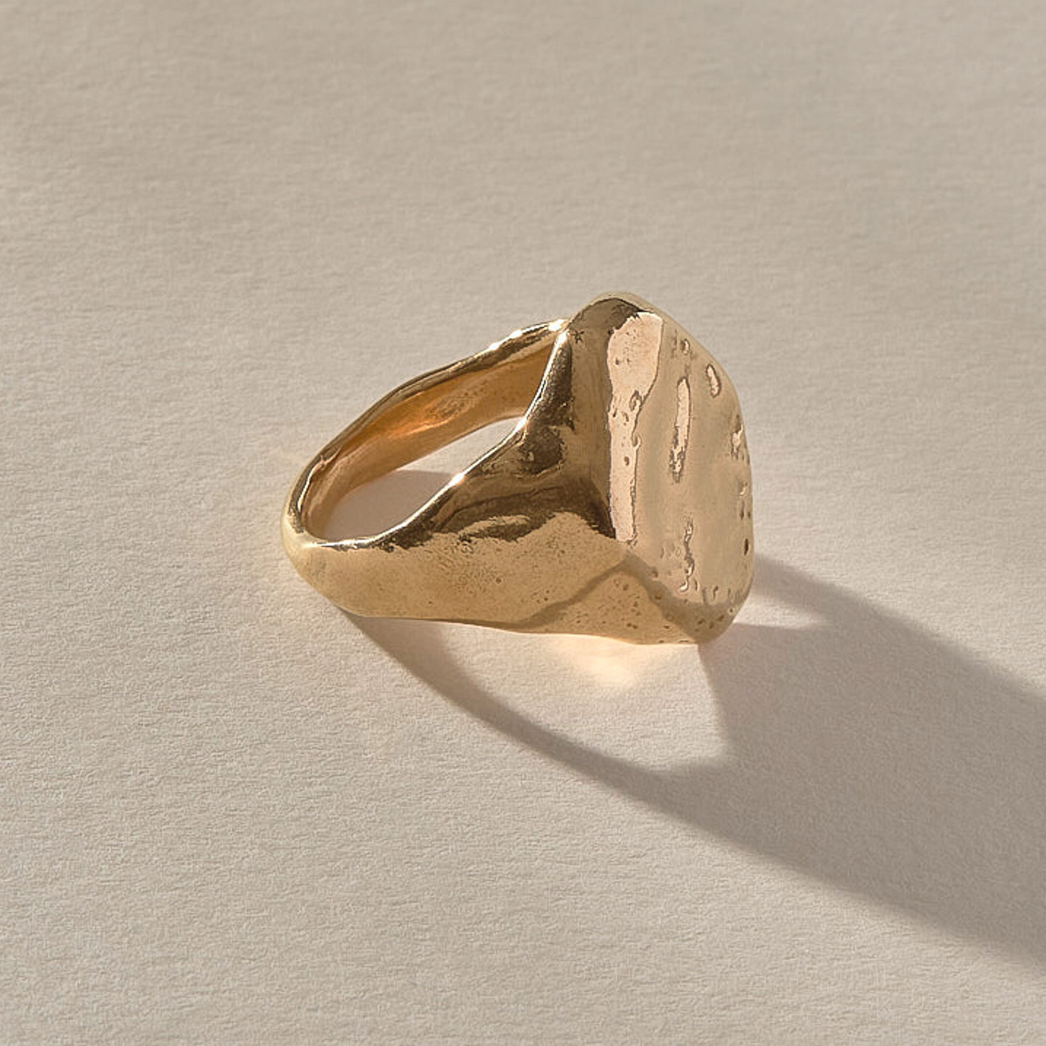Heritage Textured Signet Ring in solid recycled gold at an angle, showing the dappled signet face.