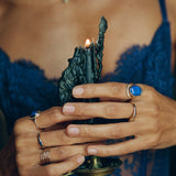 Model in blue lace holding a raw dark crystal, wearing the gold Inanna Lapis Shield Ring.