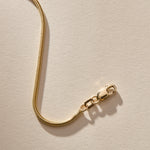 Close up of the 14k gold Jera Snake Chain clasp and links.