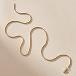 14k gold Jera Snake Chain, 1.55mm wide, laid in a flowing curve with its clasp.
