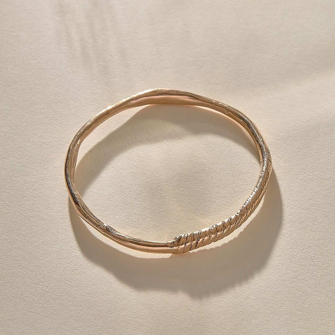 Rustic Magi Bangle in bronze at an angle, showing the spiral markings.