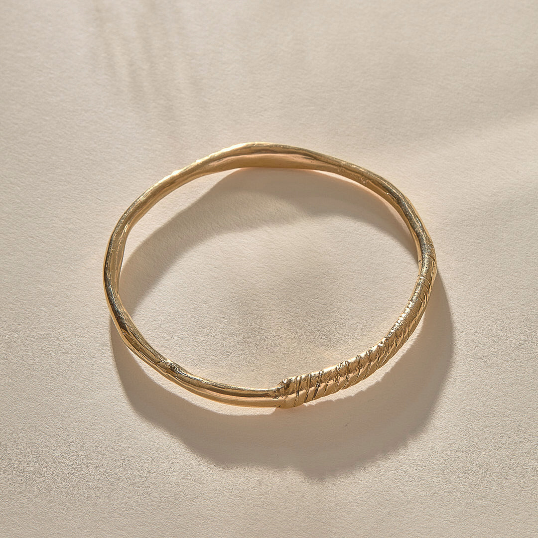Rustic Magi Bangle in gold at an angle, showing the spiral markings.