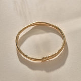 Rustic Magi Bangle in gold at an angle, showing the spiral markings.