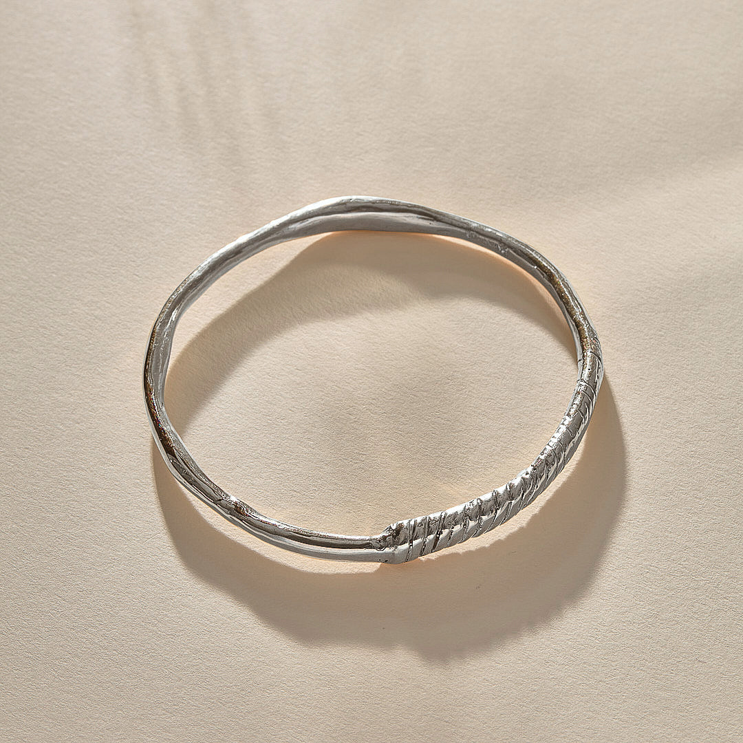 Rustic Magi Bangle in sterling silver at an angle, showing the spiral markings.