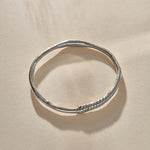 Rustic Magi Bangle in sterling silver at an angle, showing the spiral markings.