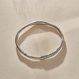 Rustic Magi Bangle in sterling silver at an angle, showing the spiral markings.