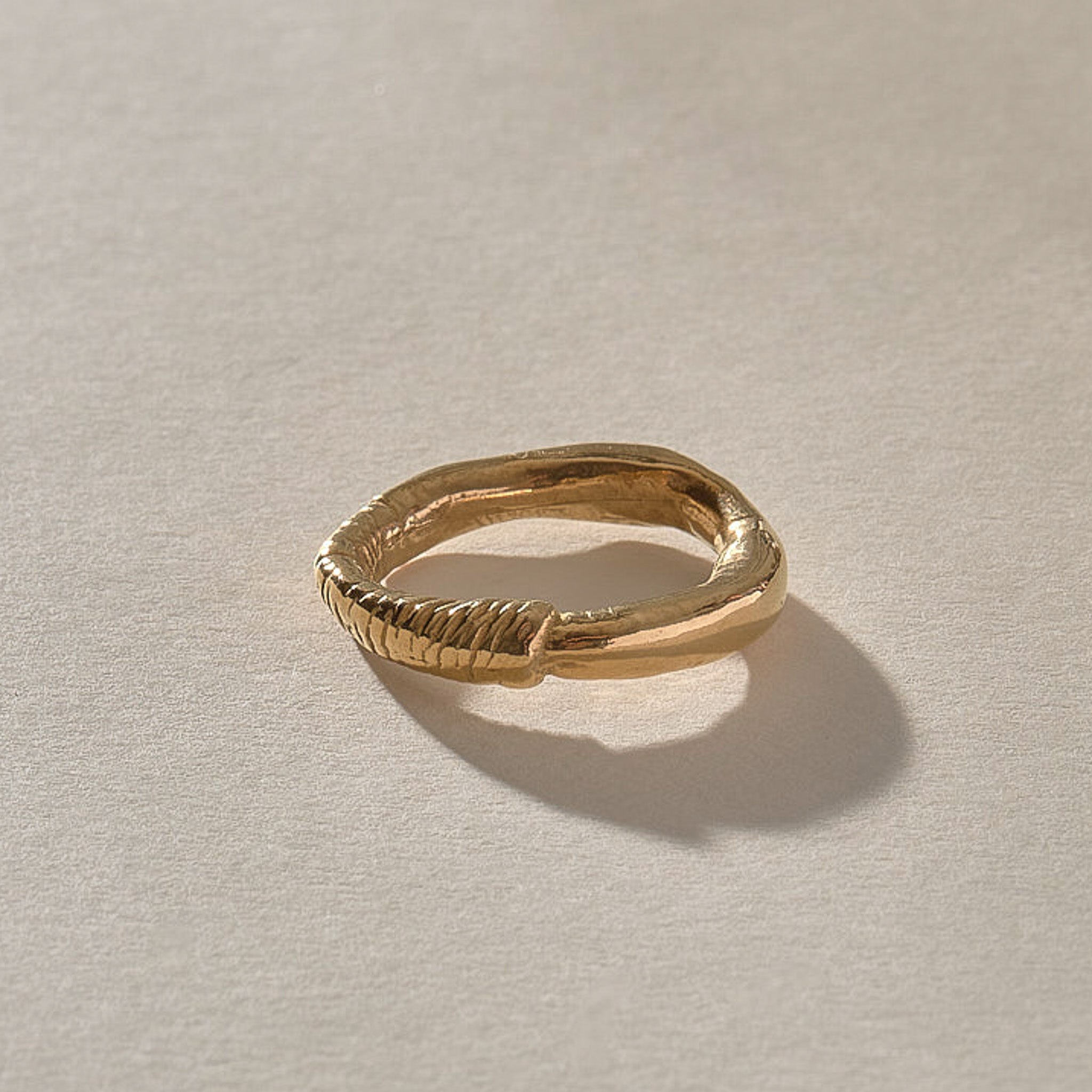 Magi Ring in solid recycled gold, angled view of the uneven hand-carved band