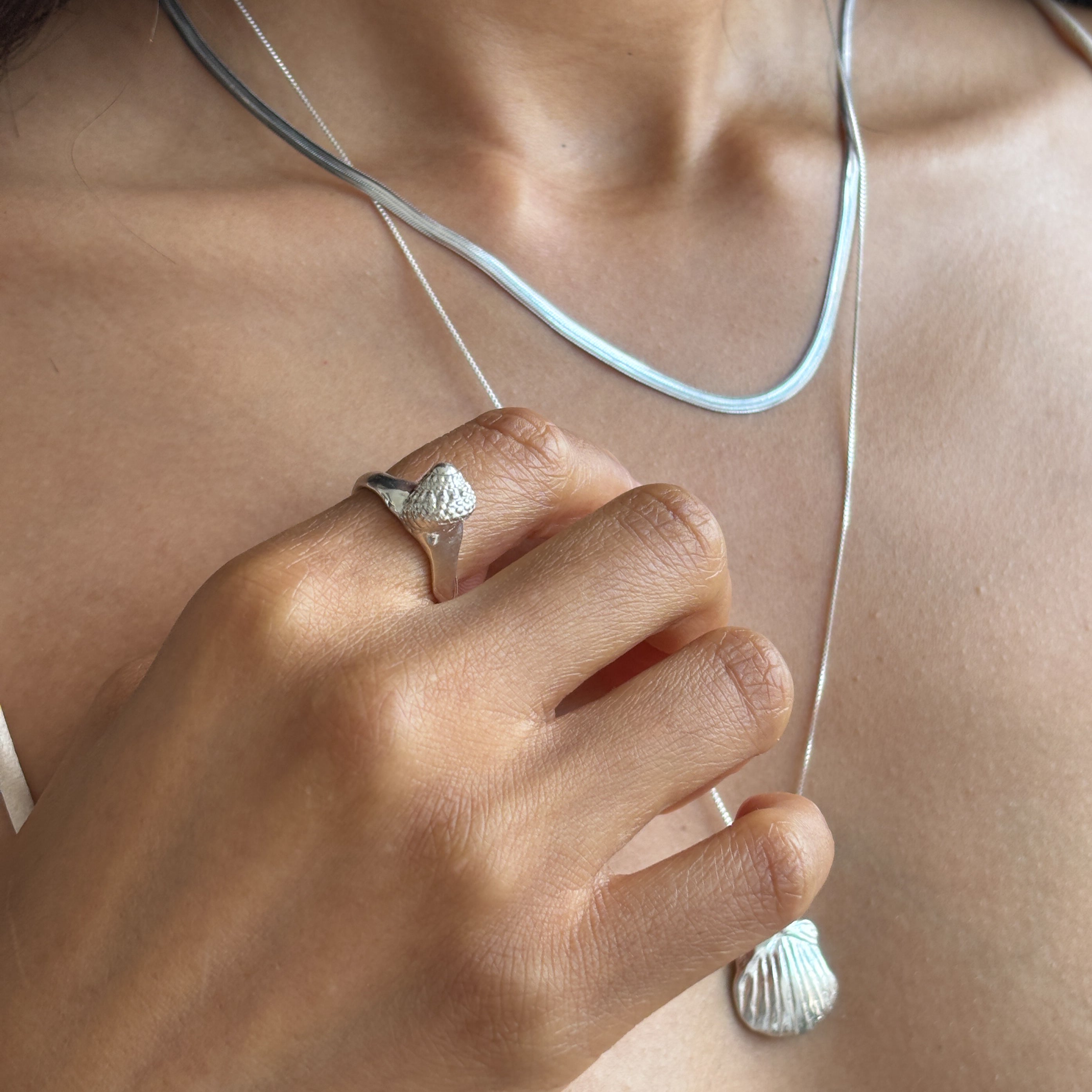 Maré Shell Ring in sterling silver worn on the hand, showing its delicate size.