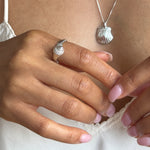 Maré Shell Ring in sterling silver on the hand, showing its delicate size from the side.