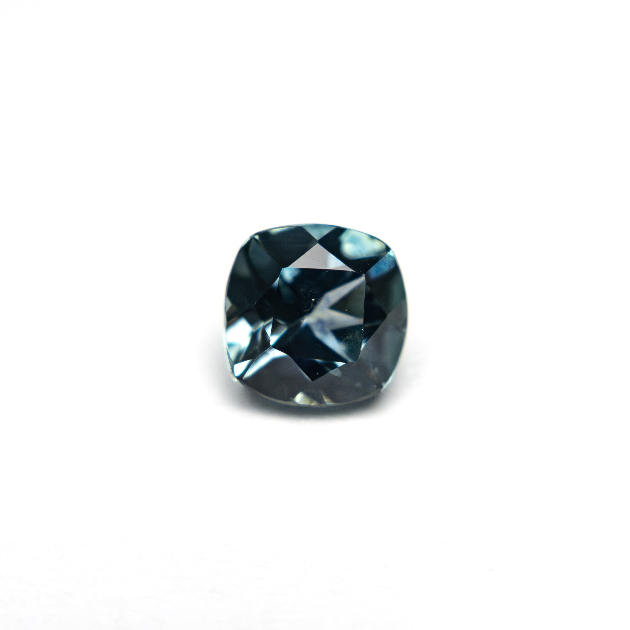 The 0.82ct brilliant cushion cut Montana sapphire set in the Meridian Ring, shown loose on a white background.