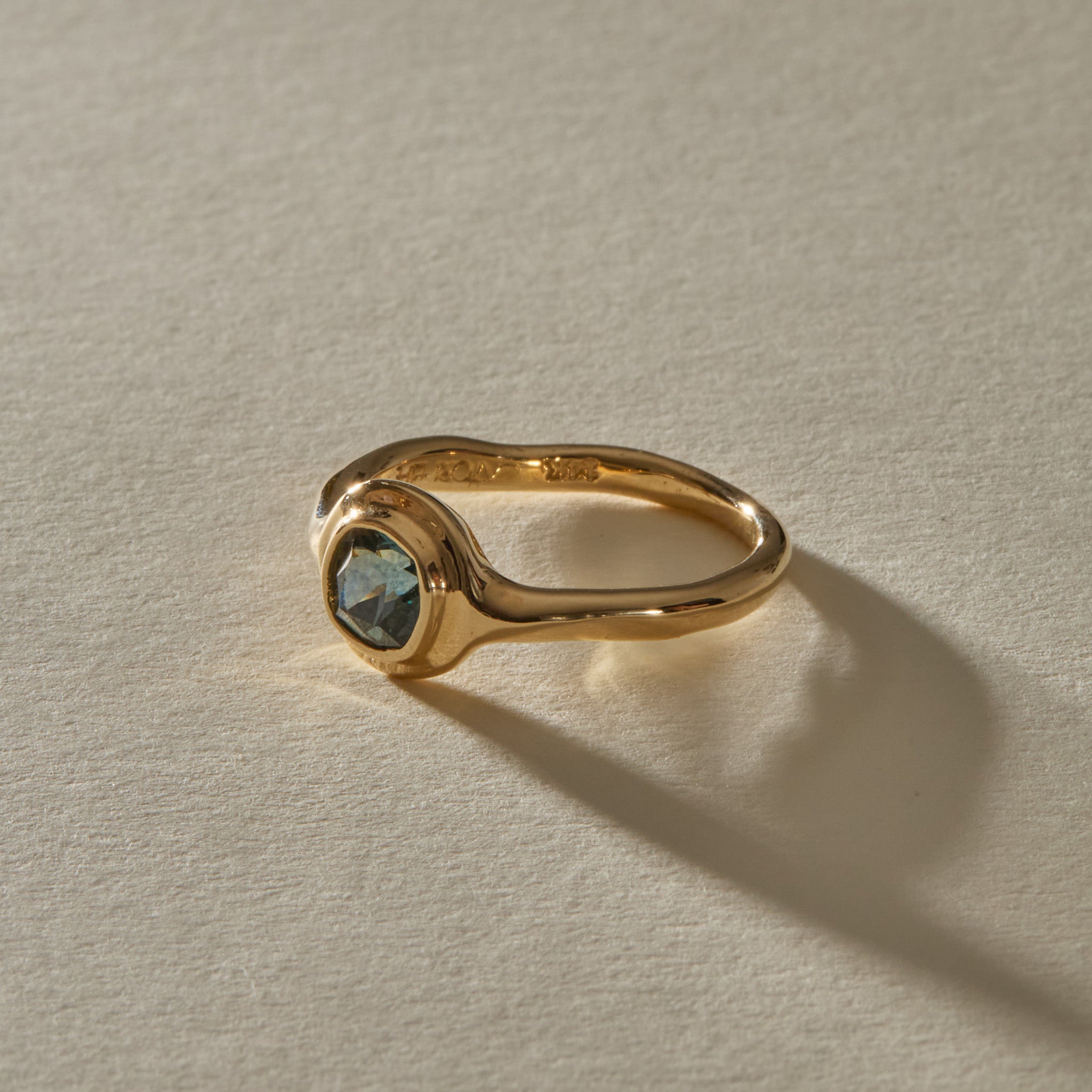 Meridian Ring in 14k gold at an angle, with the hand-formed band flowing into the sapphire bezel.