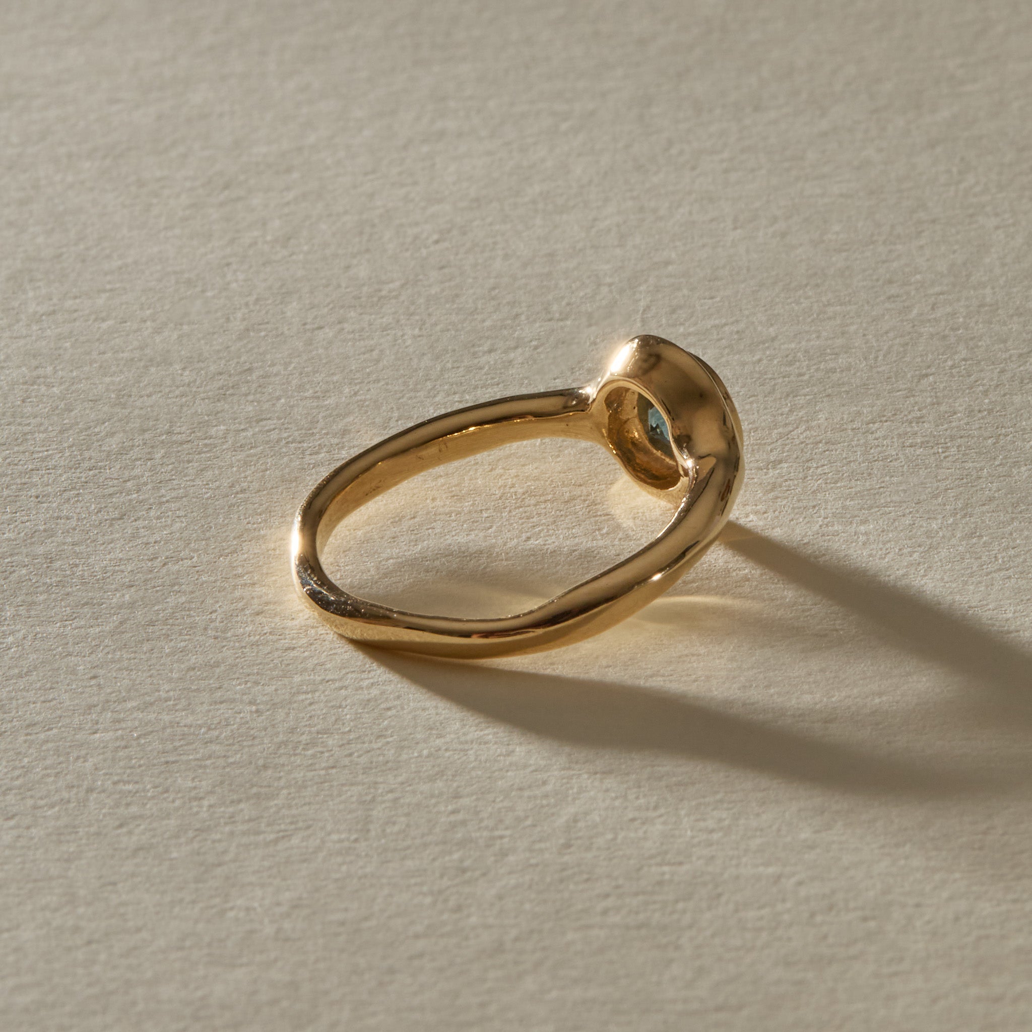 Meridian Ring in 14k recycled gold from behind, with the band curving up into the sapphire setting.