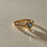 Meridian Ring in 14k recycled gold, a 0.82ct blue-teal cushion cut Montana sapphire in a bold bezel on an organic band, in warm sunlight.