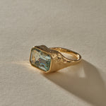 Naïade emerald cut aquamarine ring from the side, showing the water-worn texture of the gold setting.