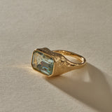 Naïade emerald cut aquamarine ring from the side, showing the water-worn texture of the gold setting.