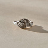 Neptune Spiral Shell Ring in sterling silver from a low angle, the spiral shell rising from the band.