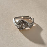 Neptune Spiral Shell Ring in recycled sterling silver, a hand-cast spiral seashell set on a wavy organic band.
