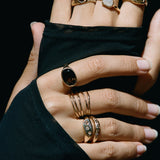 Model's hands against black fabric, wearing Nova stacking rings layered with other Catori Life rings.