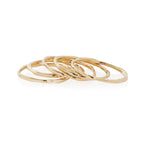 Nova gold stacking rings lined up on a white background.