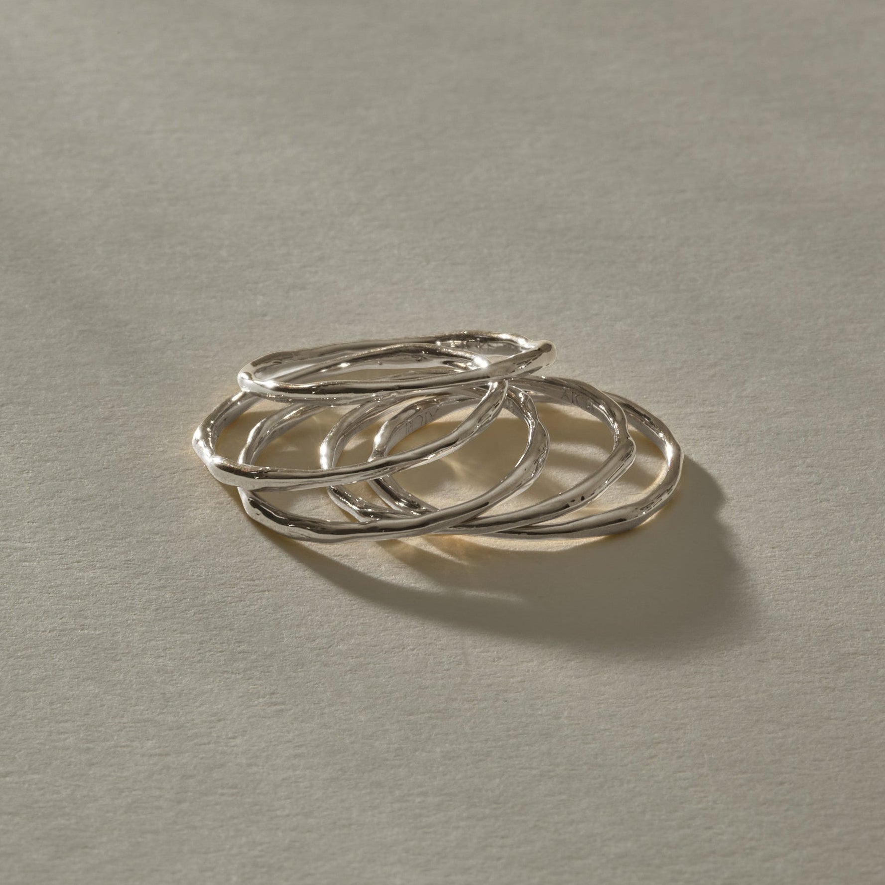 Nova Stacking Rings, a set of five thin, softly imperfect bands in recycled sterling silver, stacked together.