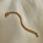 Oro Sagrado Cuban Link Bracelet in 14k gold laid flat, showing the full length of the curb chain.