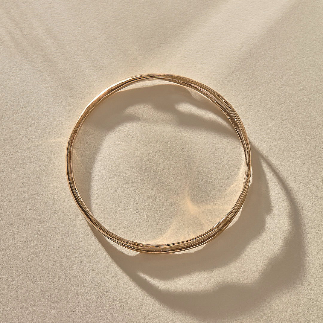 Reverie Organic Bangle in bronze from above, showing its flowing, river-like shape.