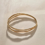 Reverie Organic Bangle in gold at an angle, showing the split band and organic texture.
