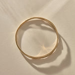 Reverie Organic Bangle in gold from above, showing its flowing, river-like shape.