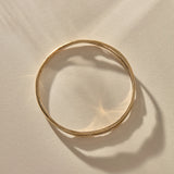 Reverie Organic Bangle in gold from above, showing its flowing, river-like shape.
