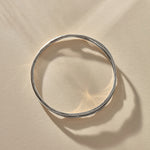 Reverie Organic Bangle in sterling silver from above, showing its flowing, river-like shape.
