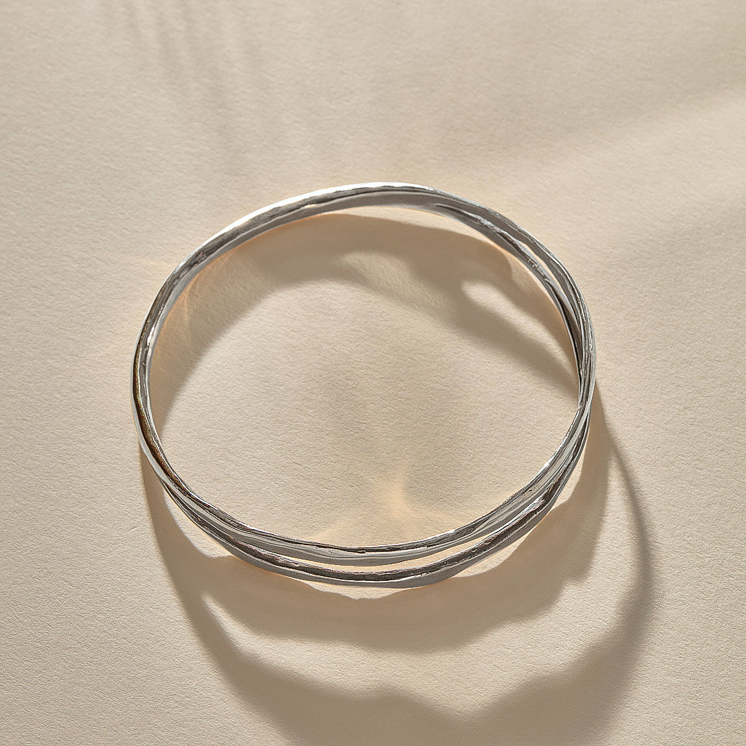 Reverie Organic Bangle in sterling silver from above in soft shadow, showing the split band.
