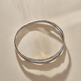 Reverie Organic Bangle in sterling silver from above in soft shadow, showing the split band.