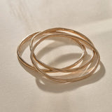 Set of 3 Rustic Bangles in bronze at an angle, showing their weight and organic shape.