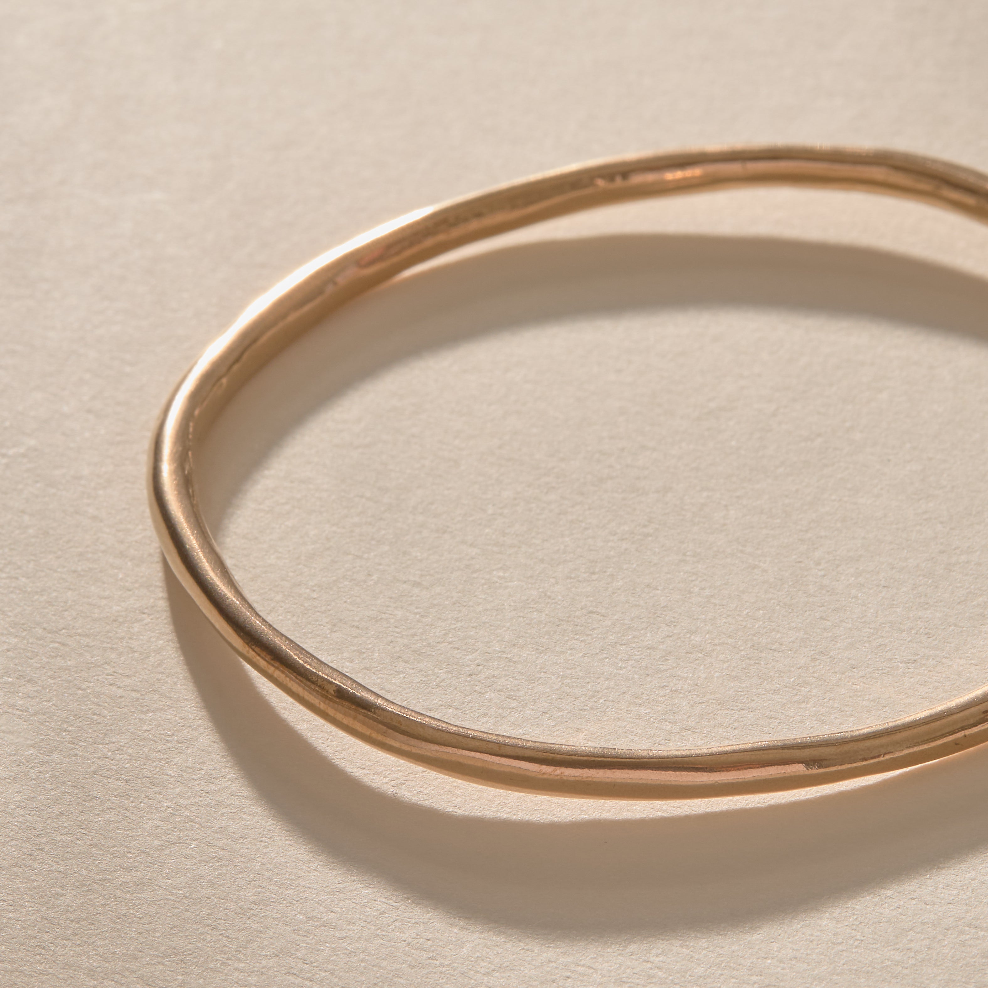 Single Rustic Bangle in bronze from above, showing its organic, slightly uneven shape.