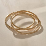 Set of 3 Rustic Bangles in gold at an angle, showing their weight and organic shape.