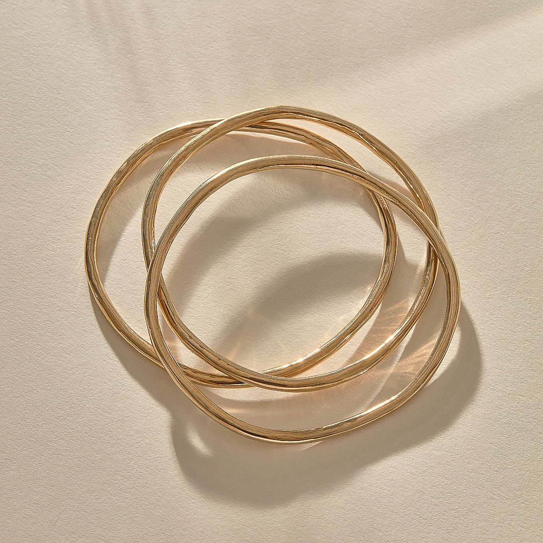 Set of 3 Rustic Bangles in solid recycled gold stacked together.
