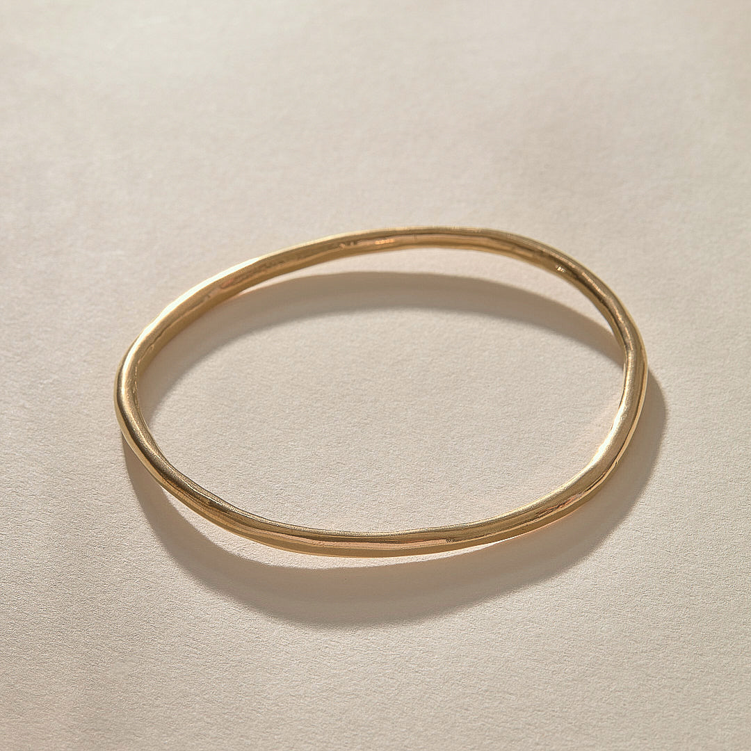 Rustic Bangle Bracelet in solid recycled gold, a single organic hand-polished bangle from above.