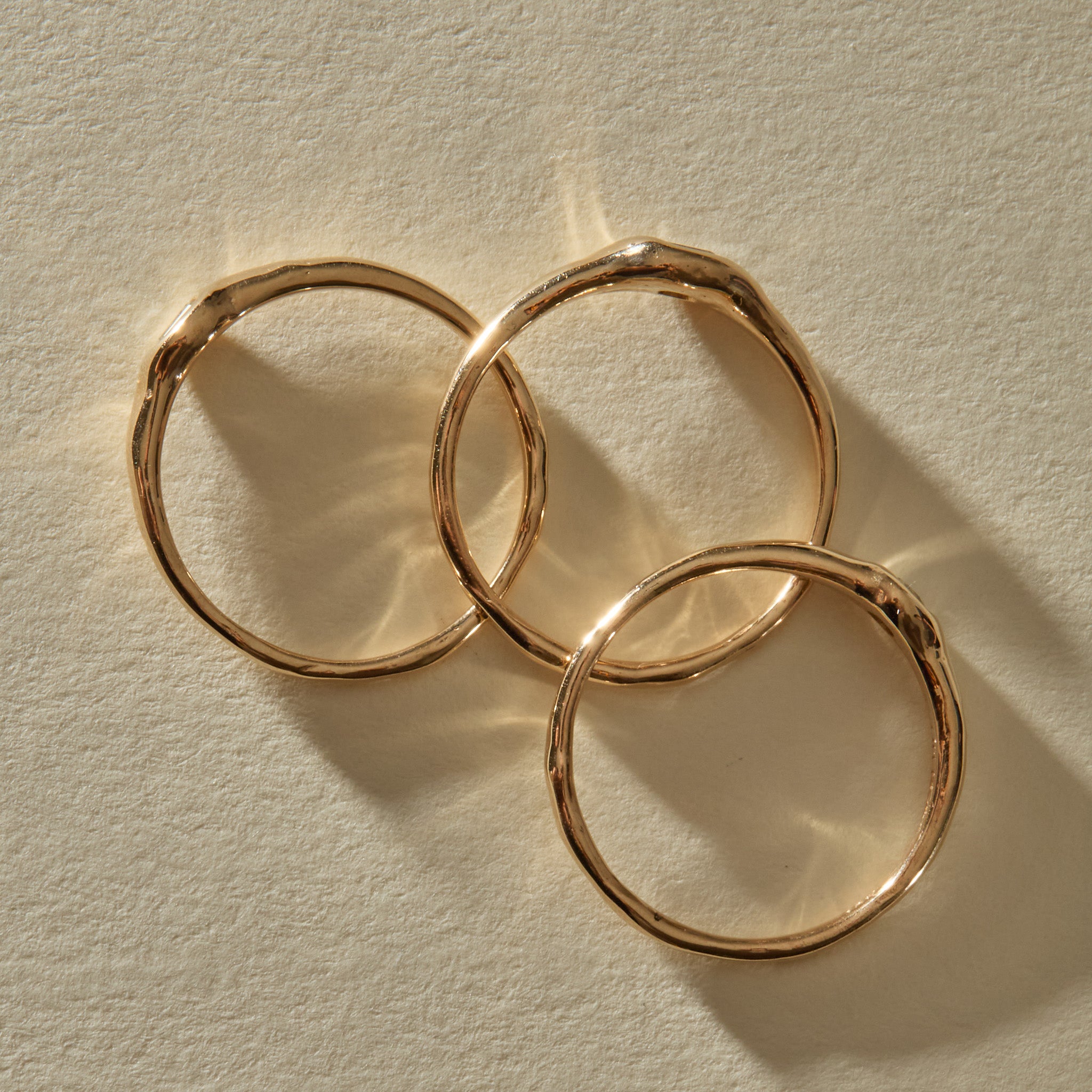 The Selkie Stack V rings from above, showing their hand-formed 10k gold bands.