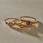 The three Selkie Stack V rings lined up side by side, each with its own natural grey diamond.