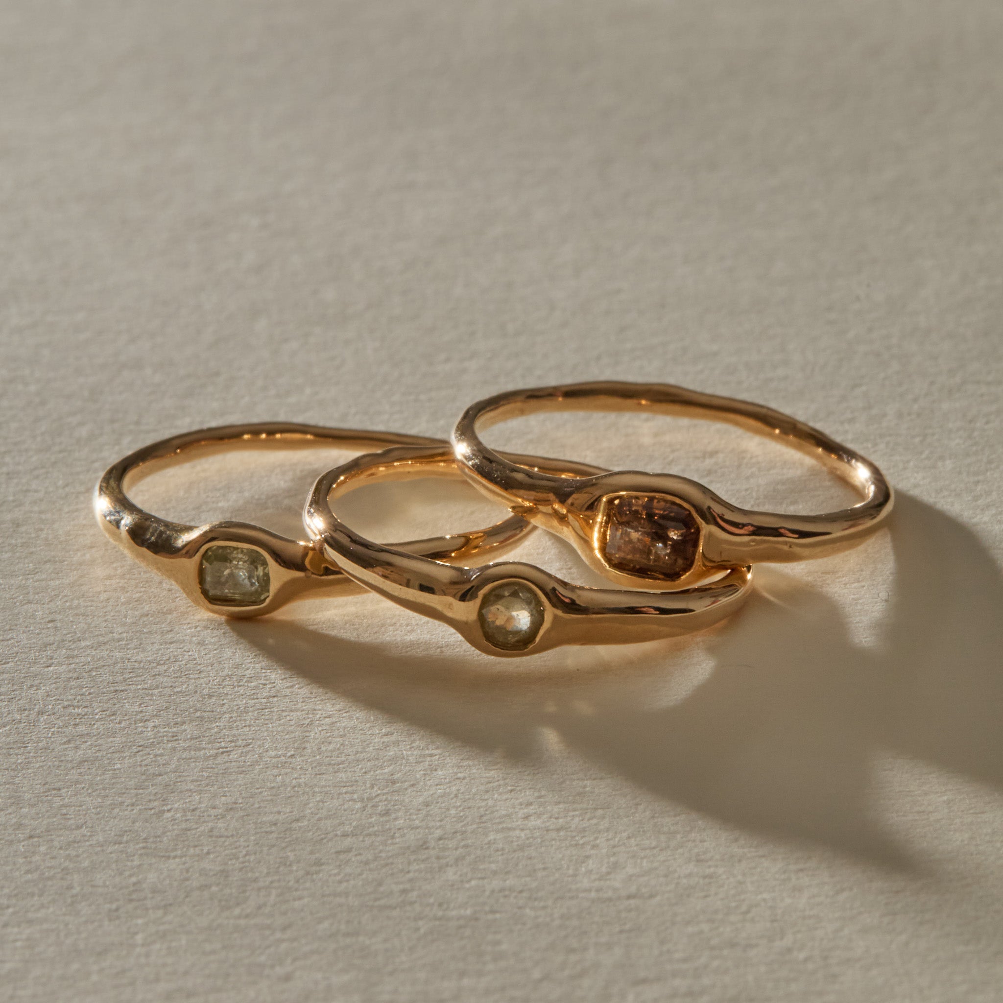 The three Selkie Stack V rings lined up side by side, each with its own natural grey diamond.