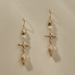 Sereia Shell and Pearl Chandelier Earrings in gold hanging side by side, showing each tier of the drop.
