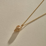 Sereia Spiral Shell Necklace in bronze, the shell pendant lying on its rolo chain.