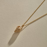 Sereia Spiral Shell Necklace in bronze, the shell pendant lying on its rolo chain.
