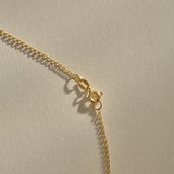 Clasp and rolo chain of the Sereia Spiral Shell Necklace in bronze.