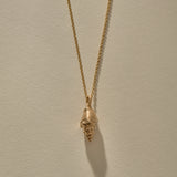 Sereia Spiral Shell Necklace in bronze, the spiral shell hanging from its chain.