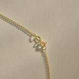 Full length of the Sereia Spiral Shell Necklace in gold on its 20 inch chain.