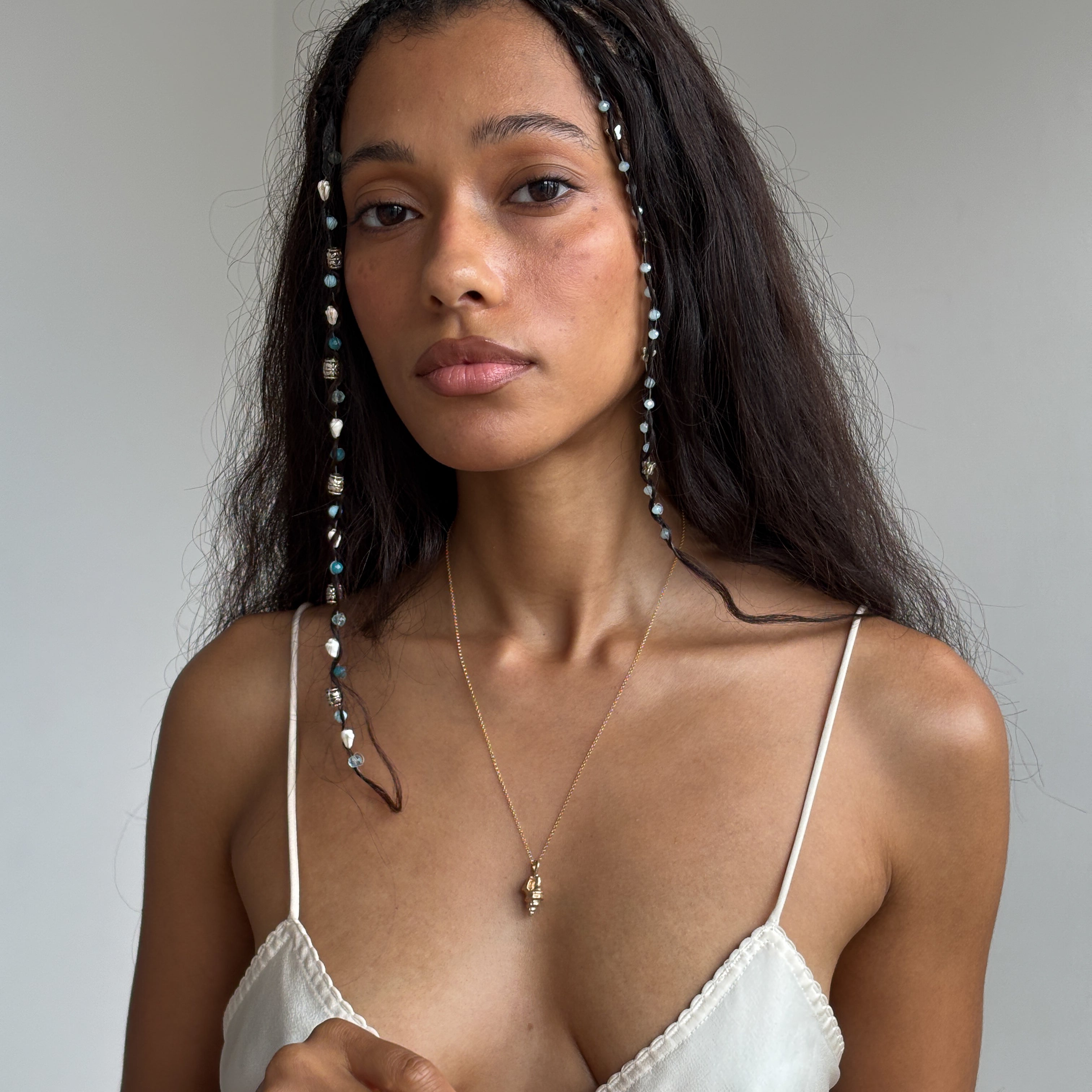 Sereia Spiral Shell Necklace worn by a model in a white top, falling to mid-chest.