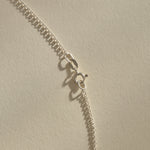 Clasp and rolo chain of the Sereia Spiral Shell Necklace in sterling silver.