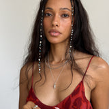 Sereia Spiral Shell Necklace in sterling silver worn by a model in a red dress, falling to mid-chest.